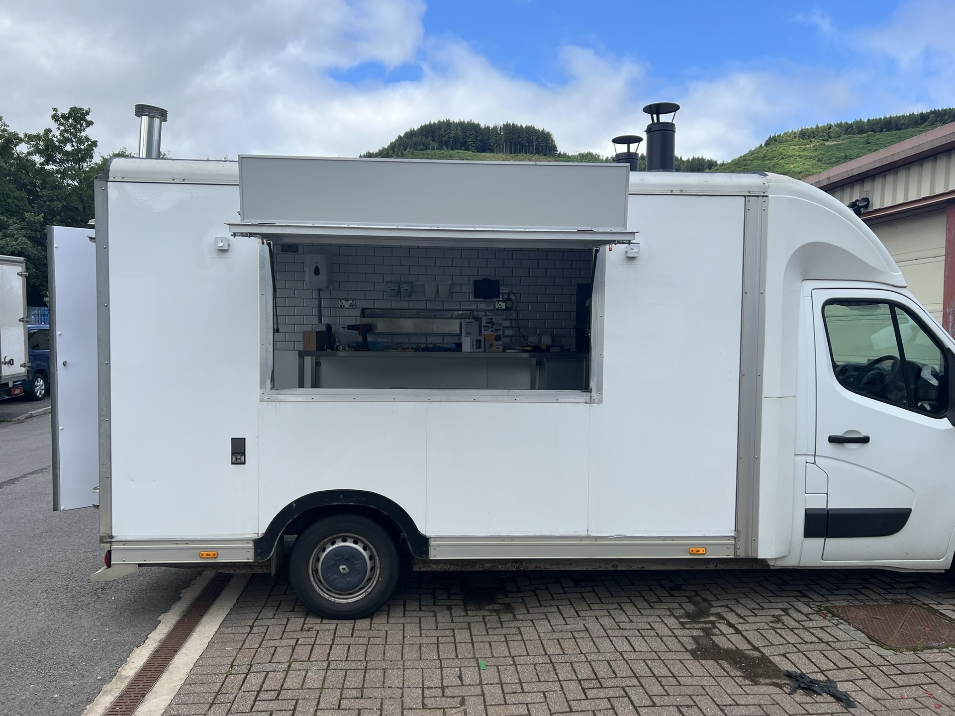The finished but unbranded white pizza van side on with the serving hatch open
