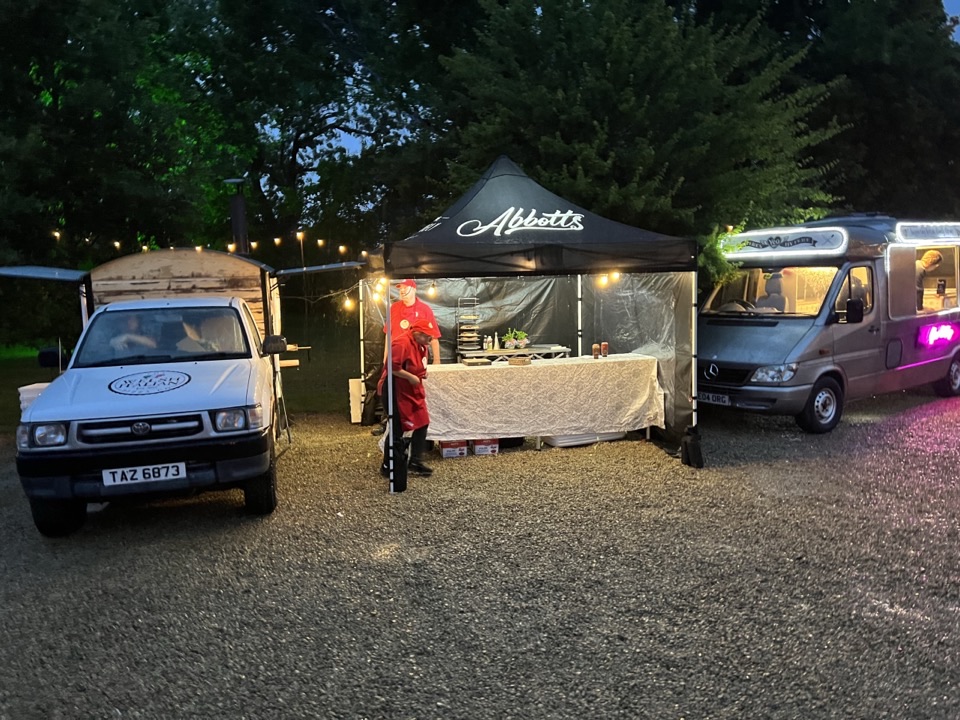The pizza truck, branded gazebo and crew set up at an evening corporate event