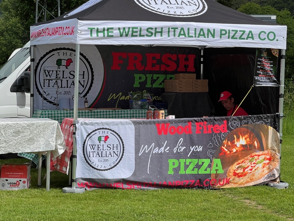 The branded gazebo and oven pitched on grass at an outdoor event