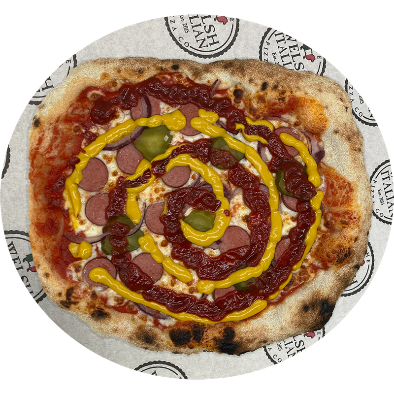 A hot dog pizza with sliced frankfurter, gherkins, ketchup and mustard