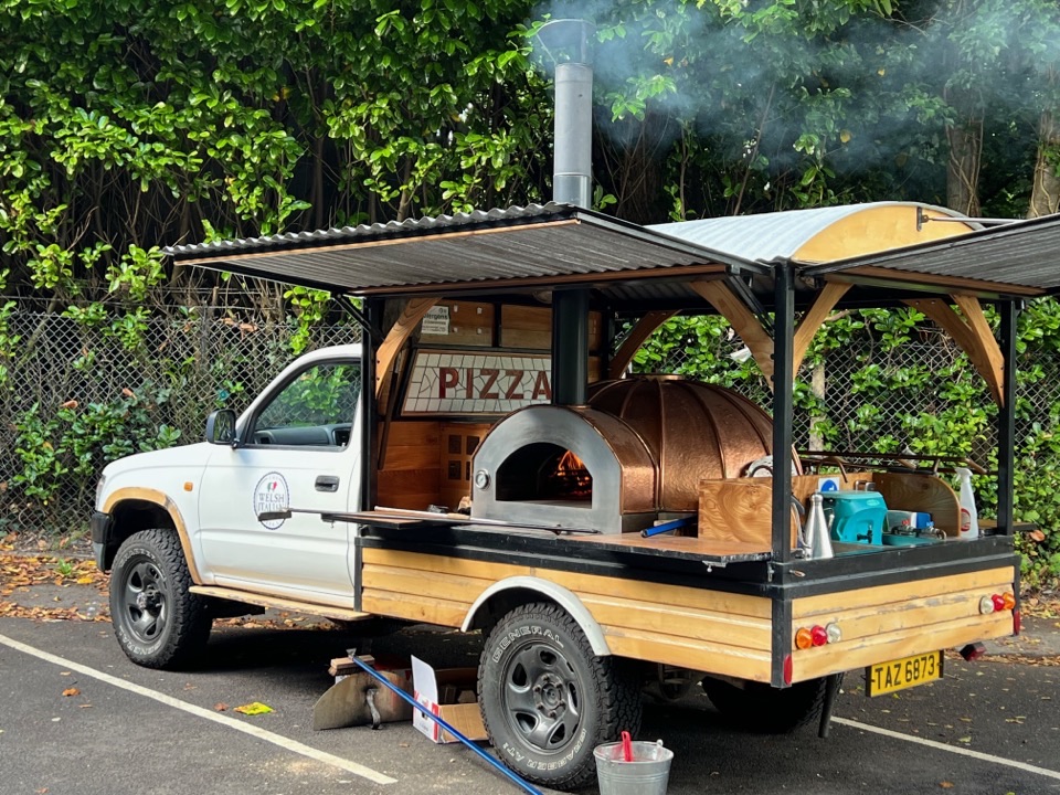 The copper oven mounted on the pickup with smoke rising from the flue